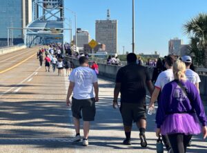 People walk across the Main Street Bridge