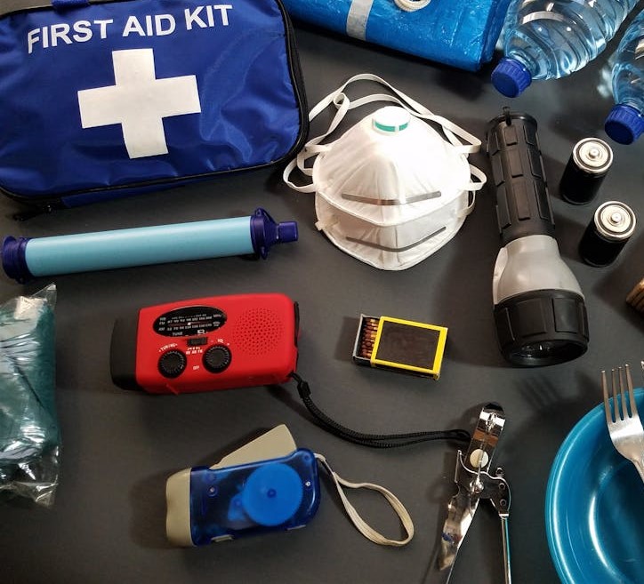 Emergency supplies on a table including a radio, first aid kit, etc.