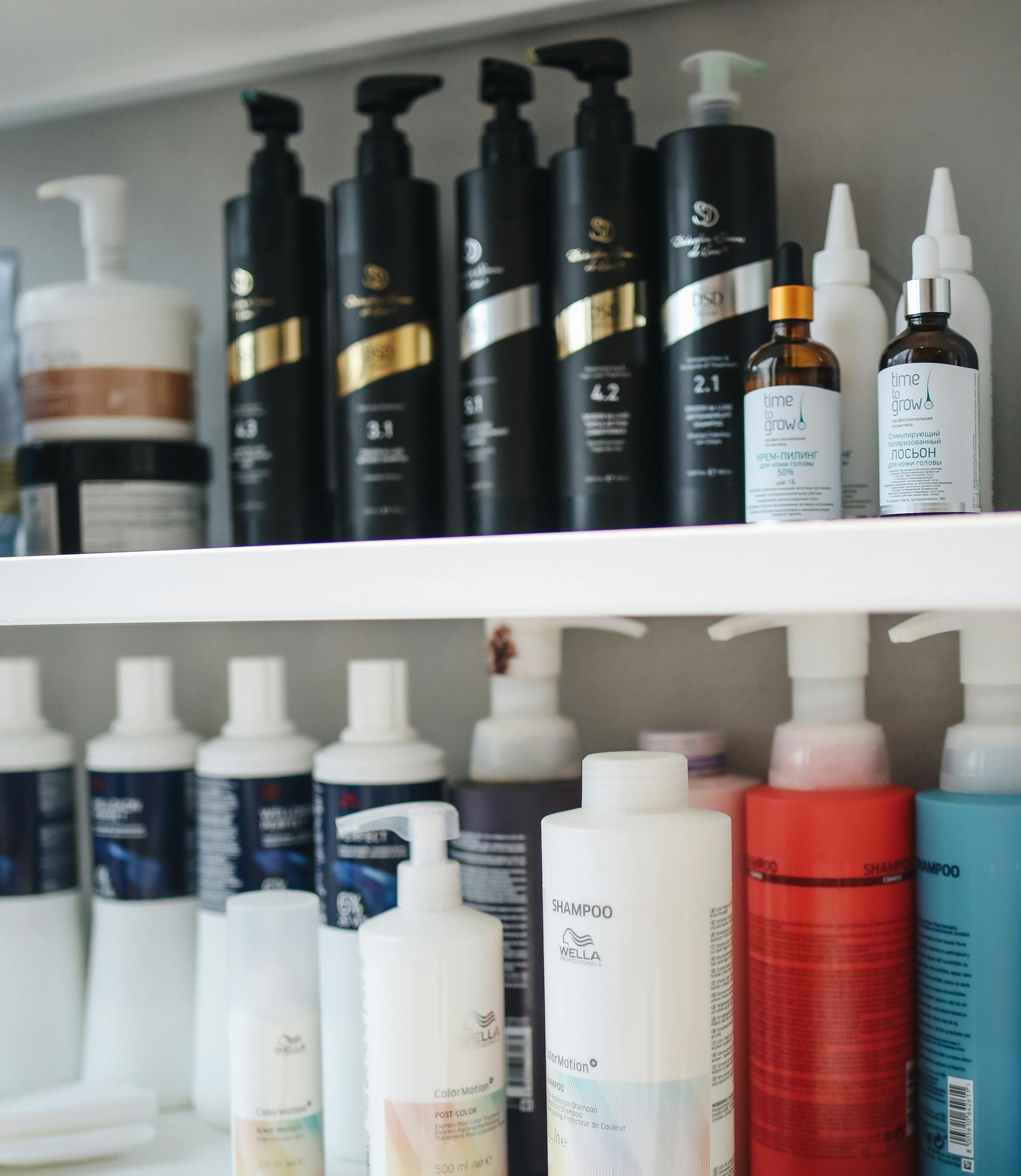 Shampoo and conditioner bottles are lined up on two shelves